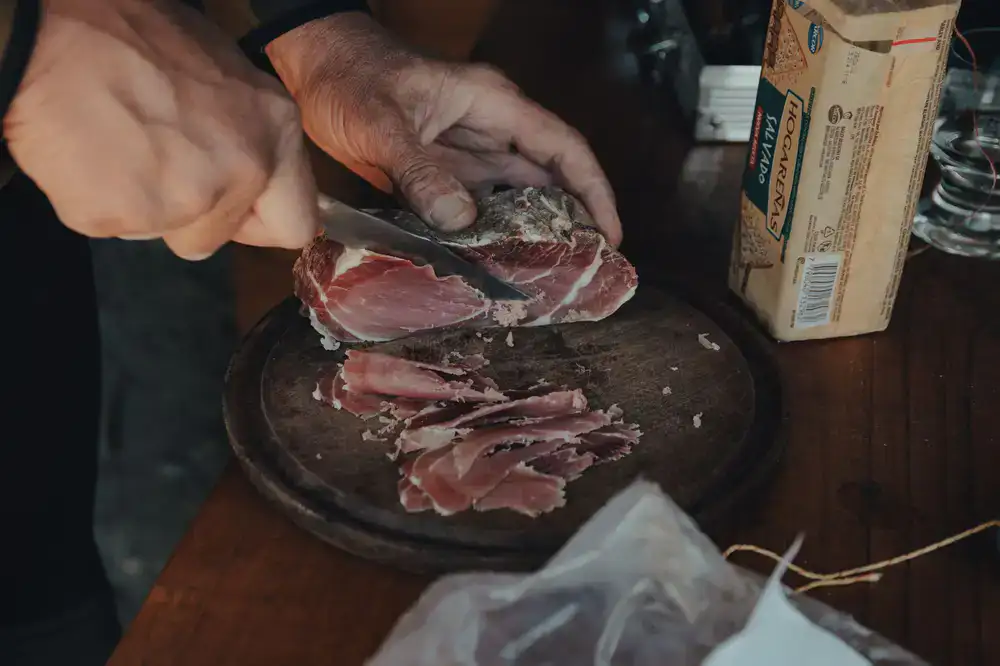 Staff slicing artisanal charcuterie behind the wooden counter