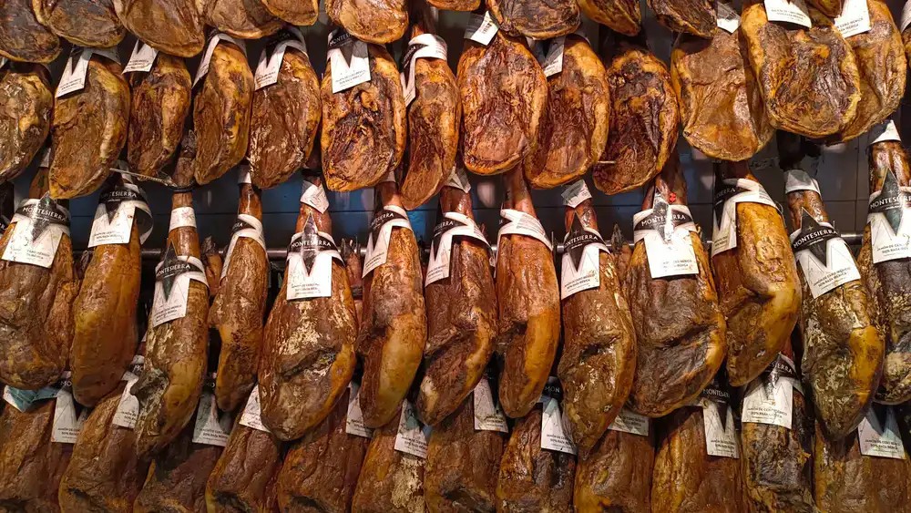 Cured hams hanging in a traditional cellar